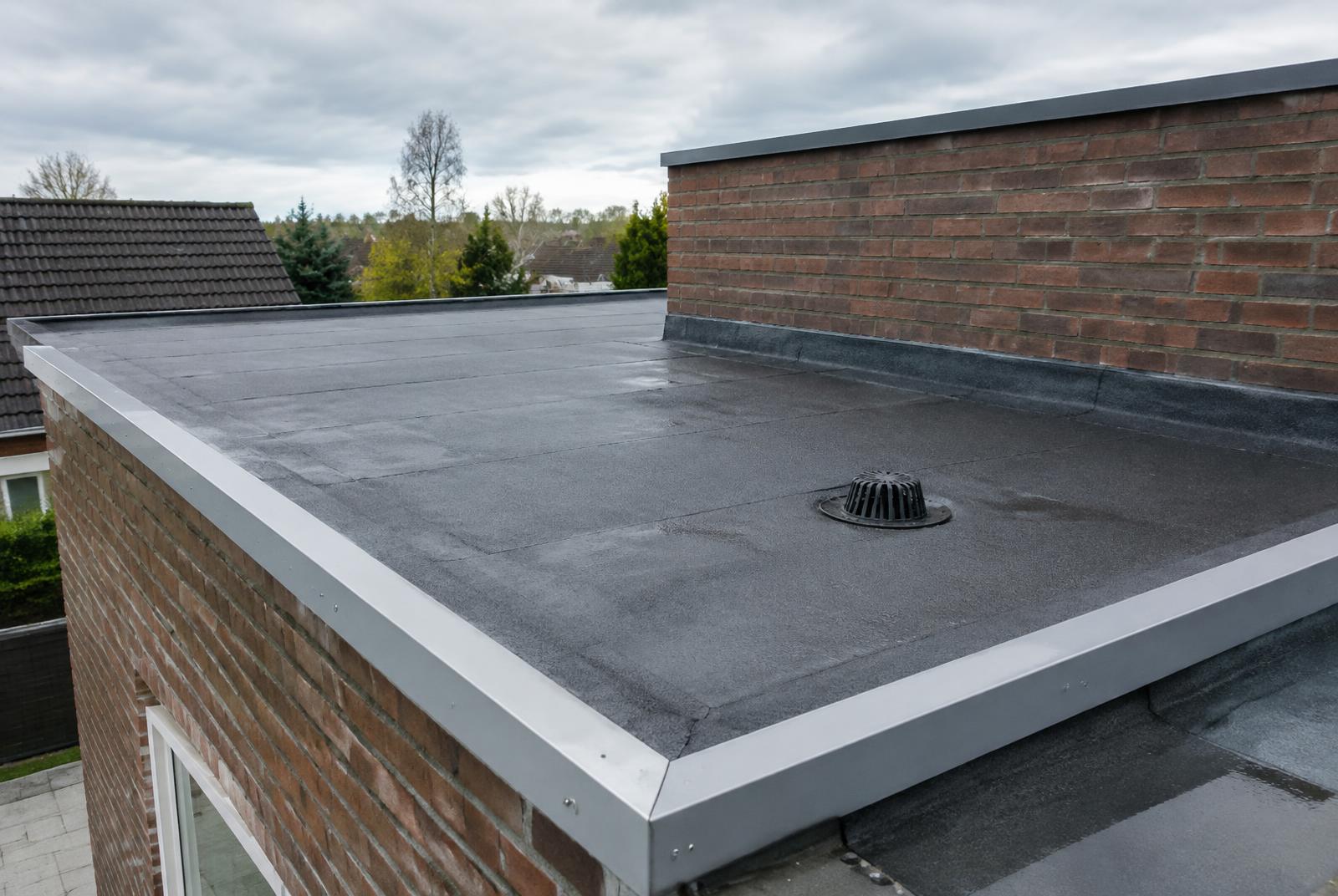 Plat dak met nieuwe bitumen dakbedekking en aluminium daktrim
